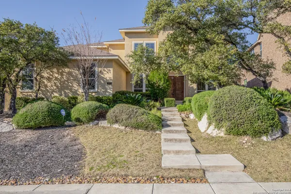 a view of a house with a yard and potted plants