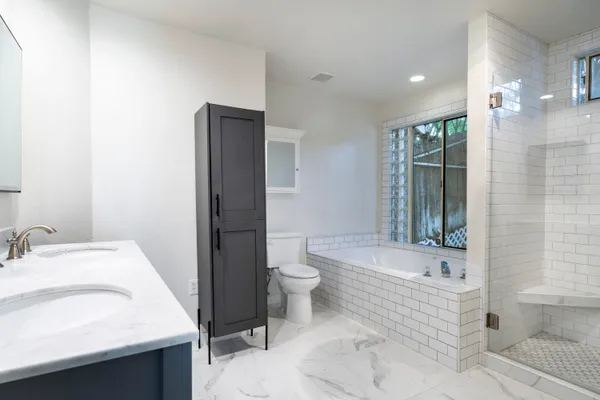 a bathroom with a sink a toilet and shower