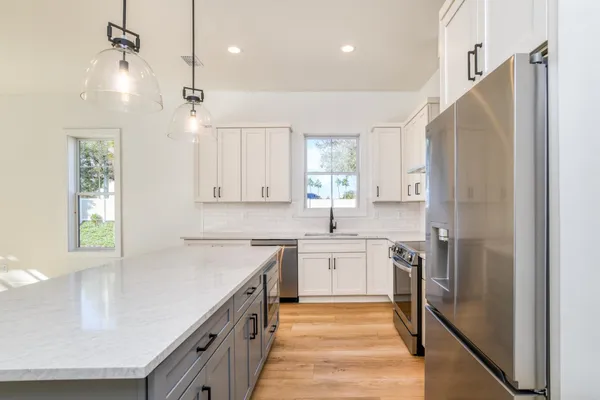 a kitchen with white cabinets and stainless steel appliances
