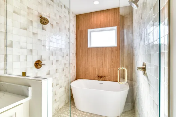 a bath tub sitting next to a white sink and a bathroom