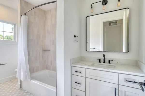 a bathroom with a tub sink and mirror