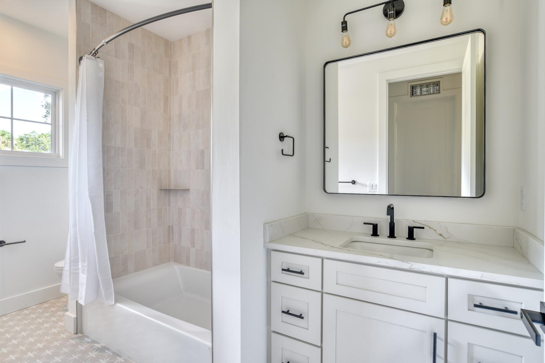 7 Sebastian Avenue, Unit C St. Augustine, FL 32084 - Photo 28 of 42 a bathroom with a tub sink and mirror