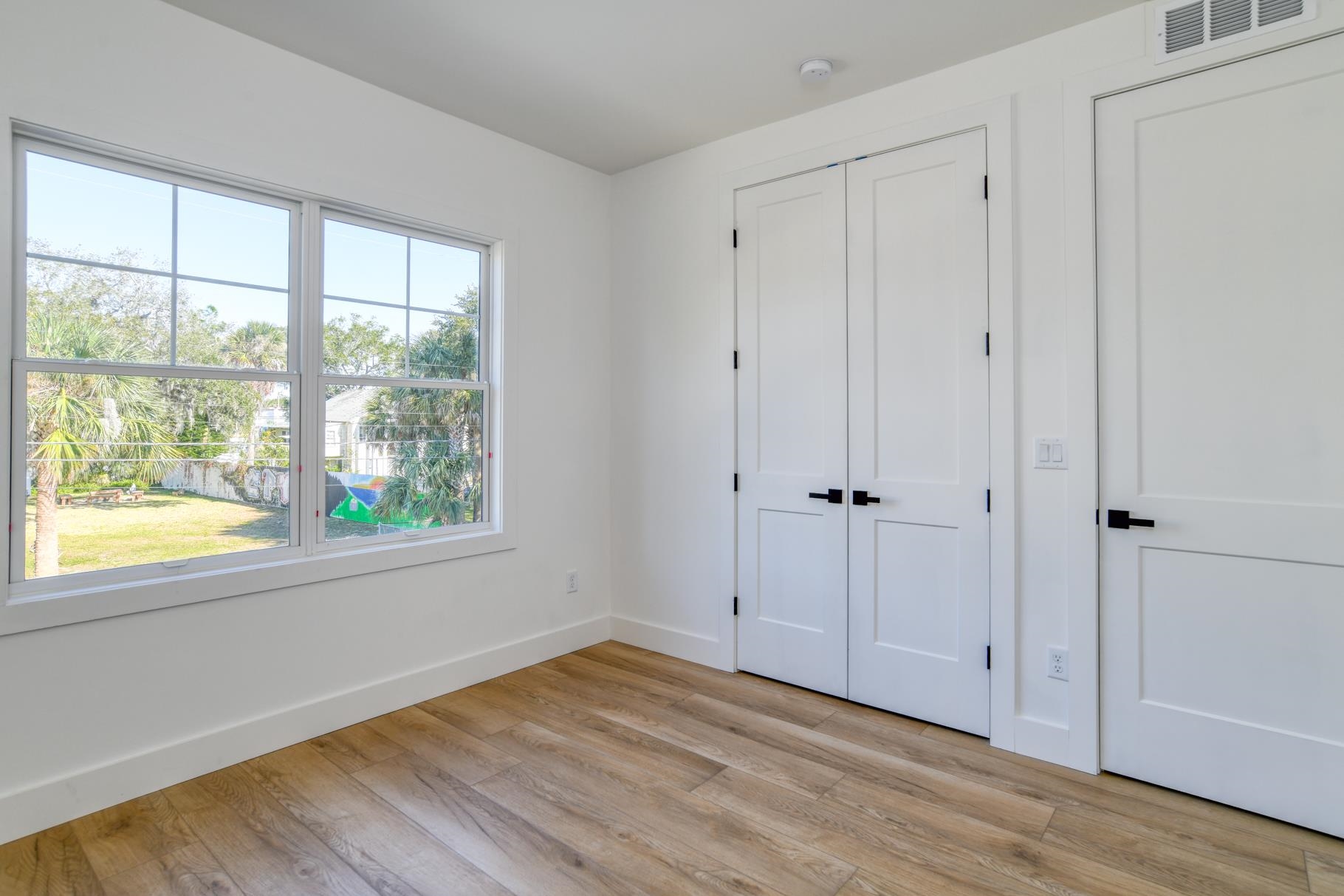 7 Sebastian Avenue, Unit C St. Augustine, FL 32084 - Photo 30 of 42 a view of an empty room with wooden floor and a window