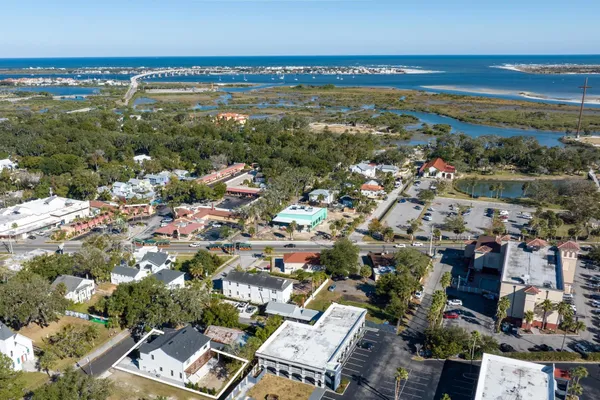 an aerial view of ocean and residential houses with outdoor space