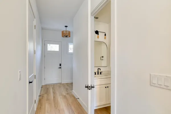a view of a hallway with wooden floor and closet