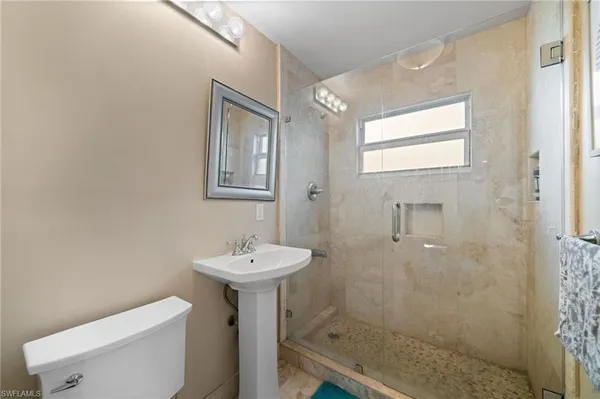 a bathroom with a sink a toilet and shower