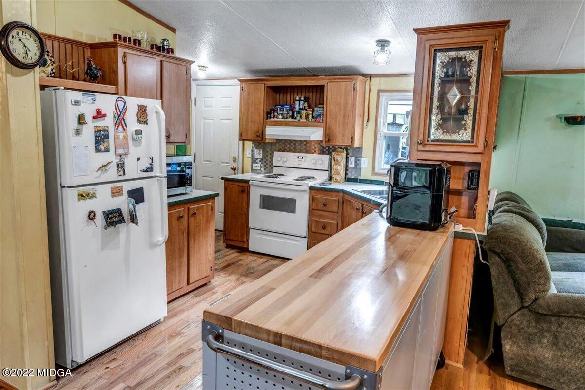 3401 Whitaker Road Roberta, GA 31078 - Photo 5 of 39 a kitchen with stainless steel appliances granite countertop a refrigerator a stove and a sink with wooden floor
