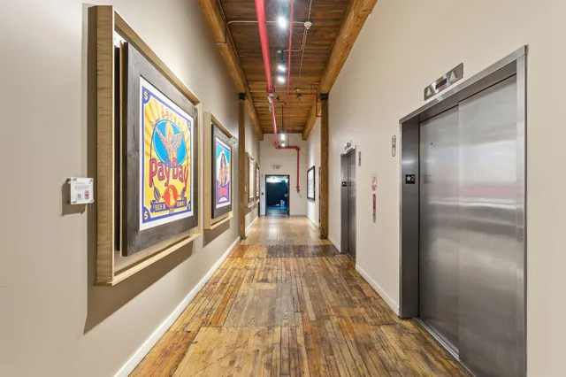 a kitchen with stainless steel appliances granite countertop a stove top oven a sink dishwasher and a microwave oven with wooden floor