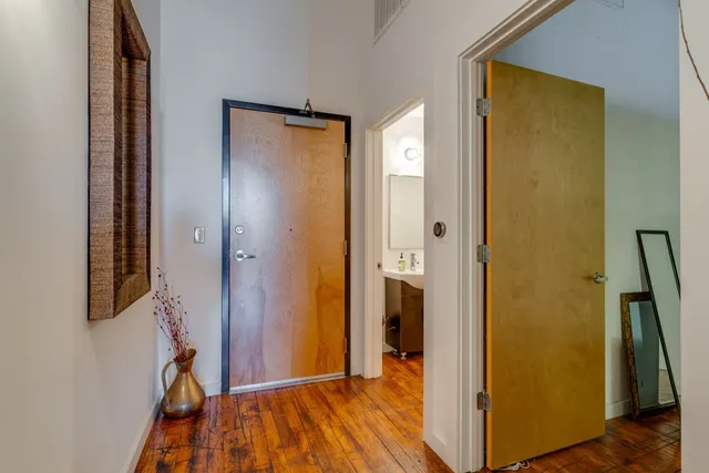 a kitchen with granite countertop a refrigerator a stove a sink a dining table and chairs with wooden floor