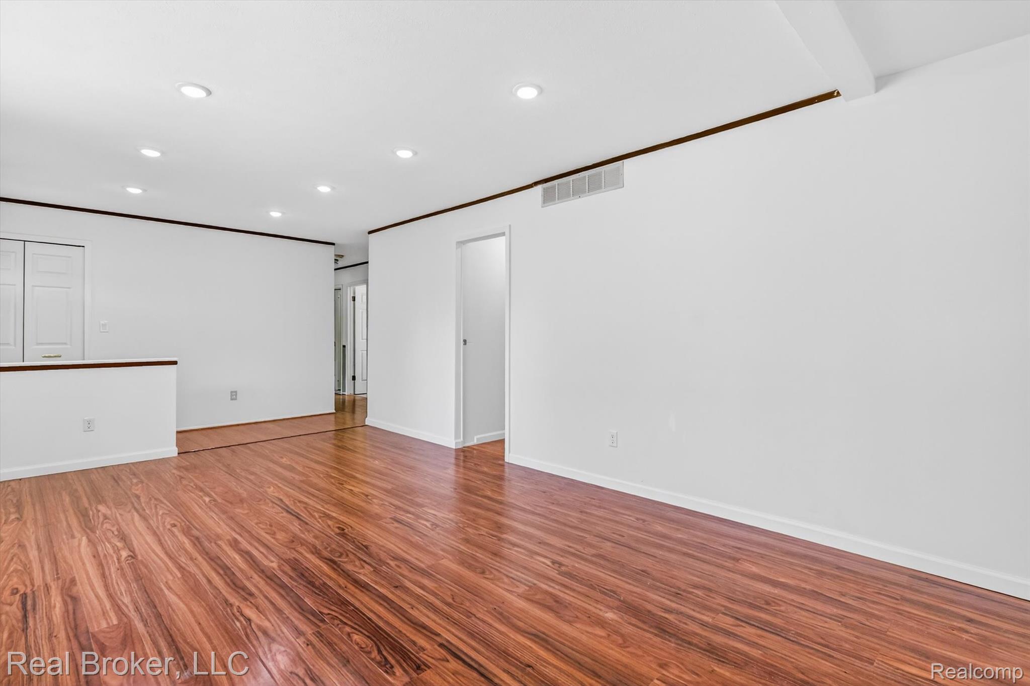 48050 Hull Road Belleville, MI 48111 - Photo 6 of 39 Expansive open-concept room featuring rich wood-finish flooring, recessed ceiling lighting, a half-wall partition, and white paneled doors
