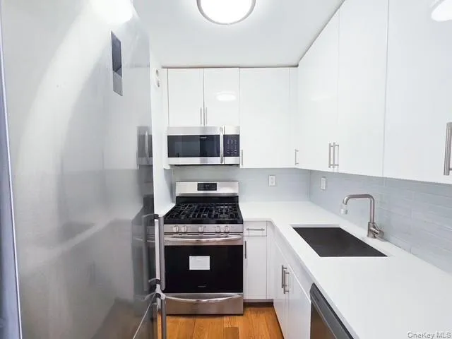 a kitchen with a sink a stove and cabinets