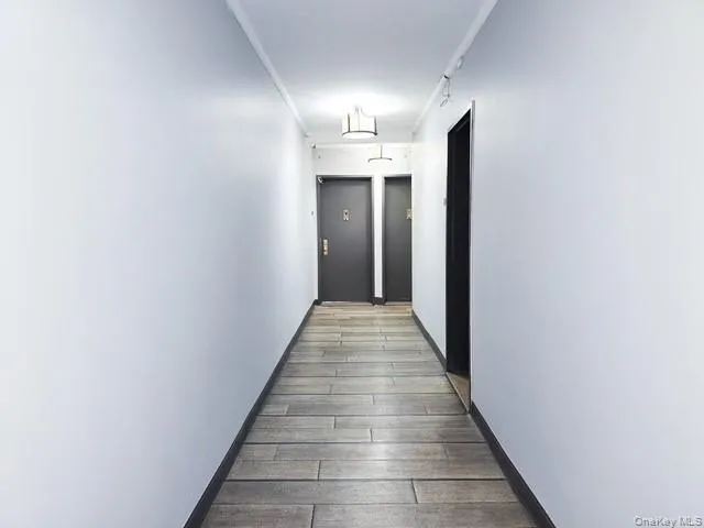 a view of a hallway with wooden floor and staircase