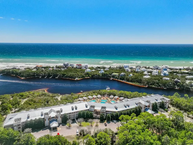 an aerial view of ocean and residential houses with outdoor space