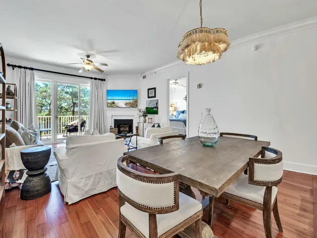 a view of a dining room with furniture a chandelier and wooden floor