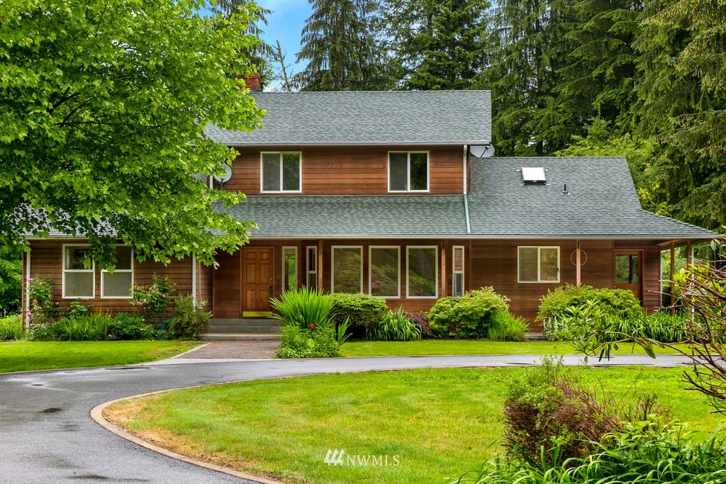 23402 Wallitner Road Arlington, WA 98223 - Photo 5 of 39 a view of a house with a yard plants and a large tree