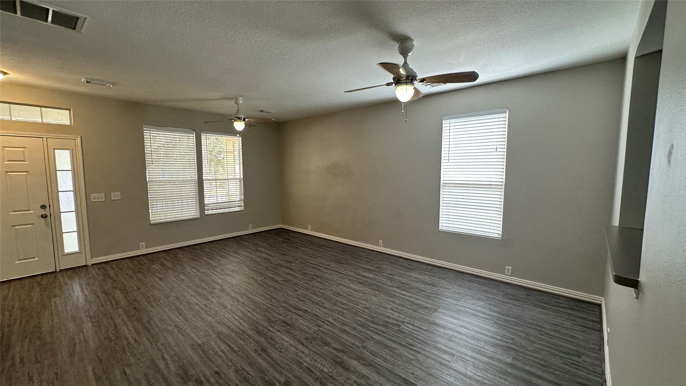 23851 Single Oak Street Spring, TX 77373 - Photo 4 of 15 an empty room with wooden floor chandelier fan and windows