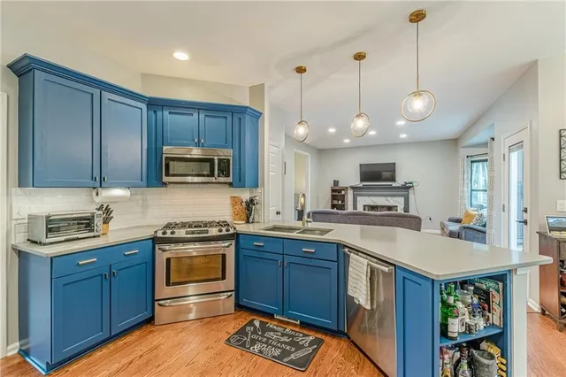 a kitchen with stainless steel appliances granite countertop a refrigerator and a stove top oven