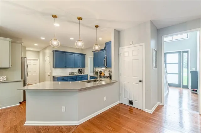 a view of a kitchen with kitchen island a sink stainless steel appliances and cabinets