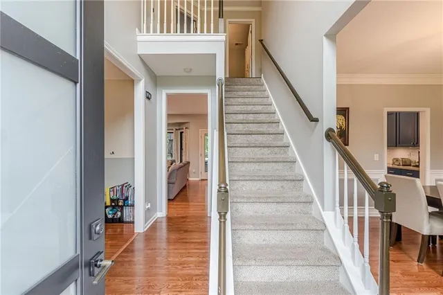 a view of staircase with lots of frames on wall and a dining table