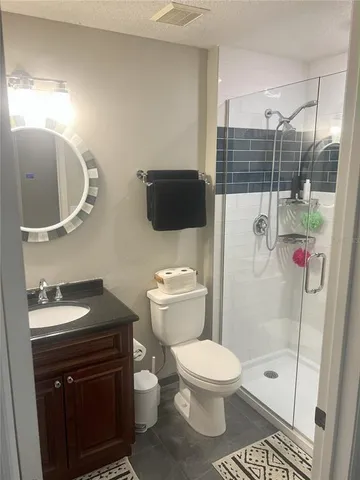 a bedroom with a bed and a lamp on dresser