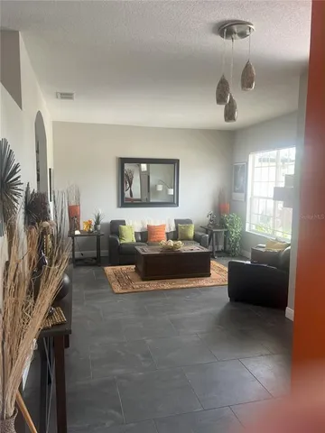 a living room with furniture a flat screen tv and a floor to ceiling window