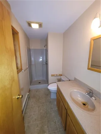 a bathroom with a granite countertop sink a toilet and a mirror