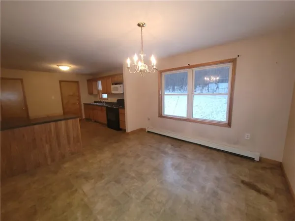 an empty room with windows and chandelier