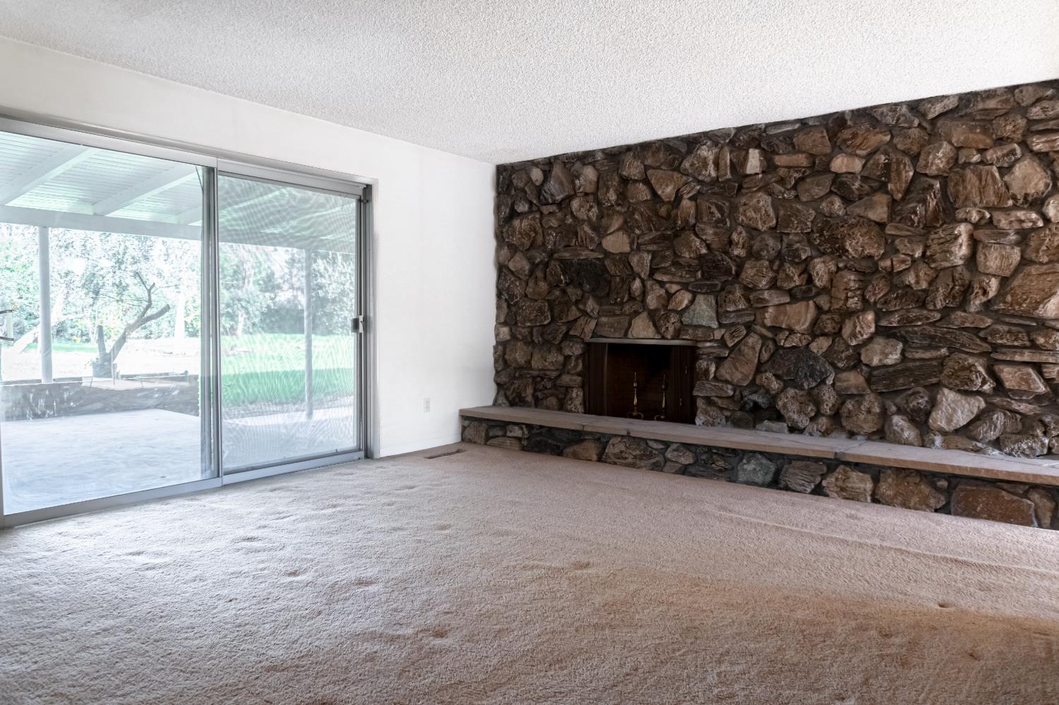 5877 East Dwight Way Fresno, CA 93727 - Photo 11 of 31 a view of an empty room with a fireplace and a window