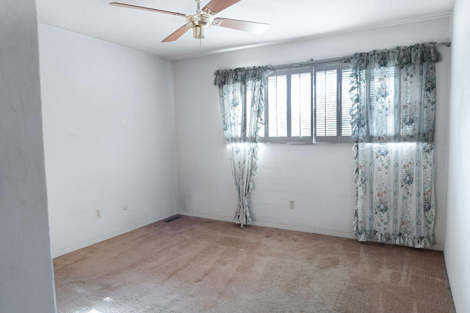 5877 East Dwight Way Fresno, CA 93727 - Photo 13 of 31 an empty room with windows and fan