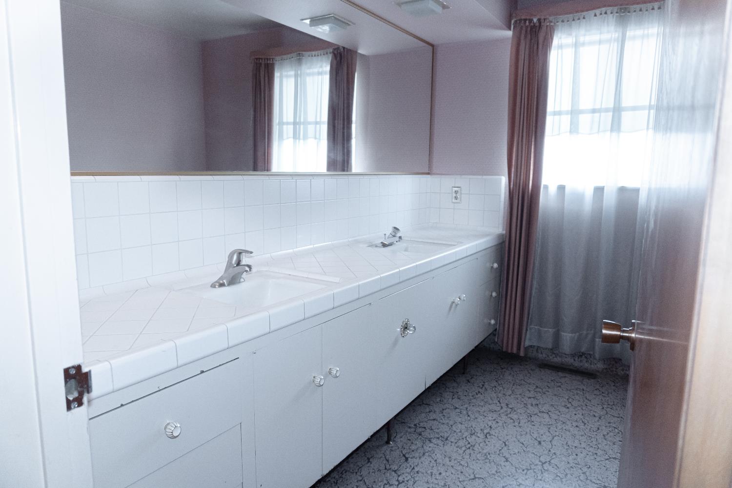 5877 East Dwight Way Fresno, CA 93727 - Photo 15 of 31 a spacious bathroom with a double vanity sink a mirror and a bathtub