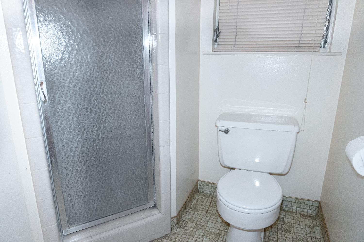 5877 East Dwight Way Fresno, CA 93727 - Photo 16 of 31 a bathroom with a toilet and a shower