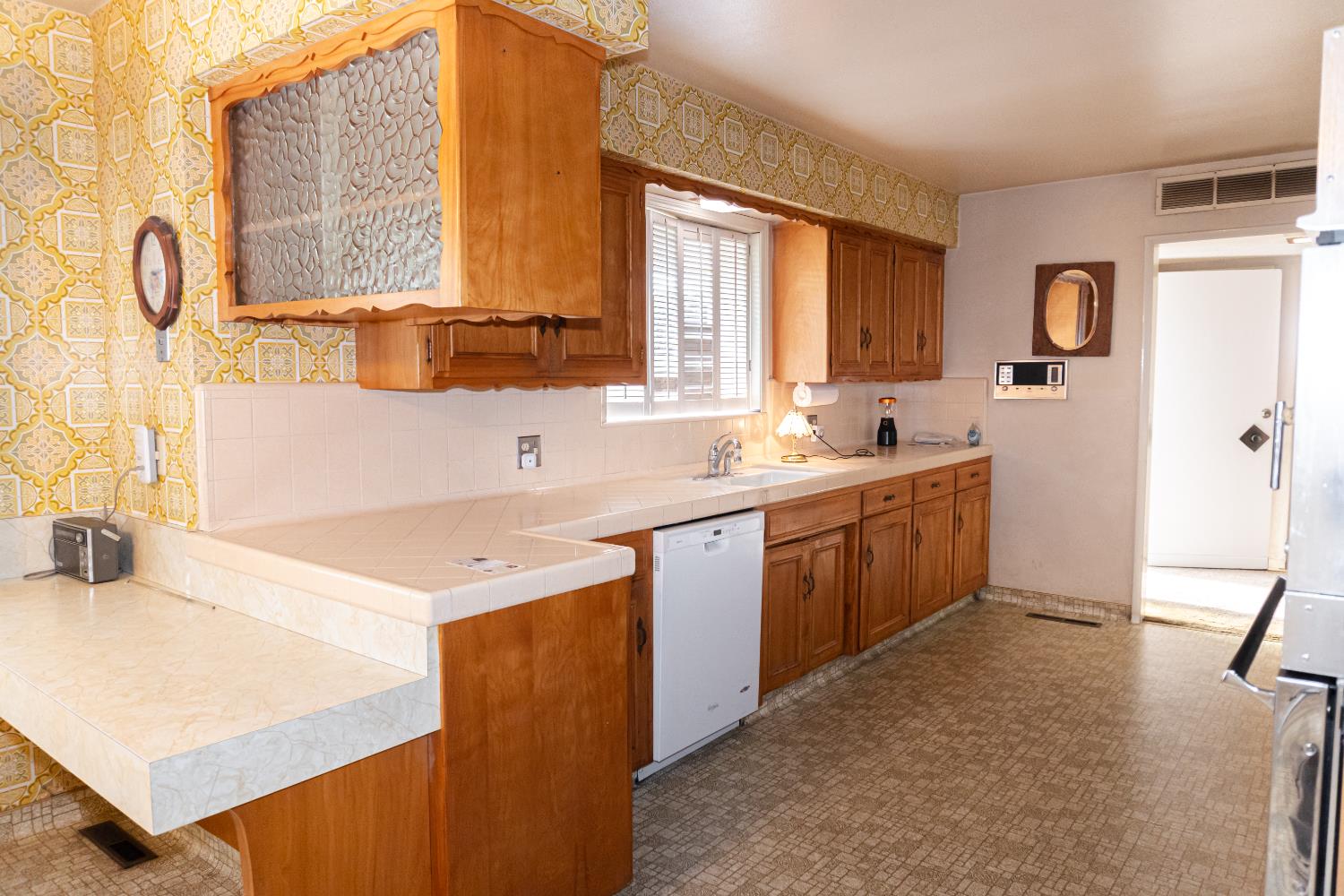 5877 East Dwight Way Fresno, CA 93727 - Photo 4 of 31 a kitchen with a sink cabinets and window