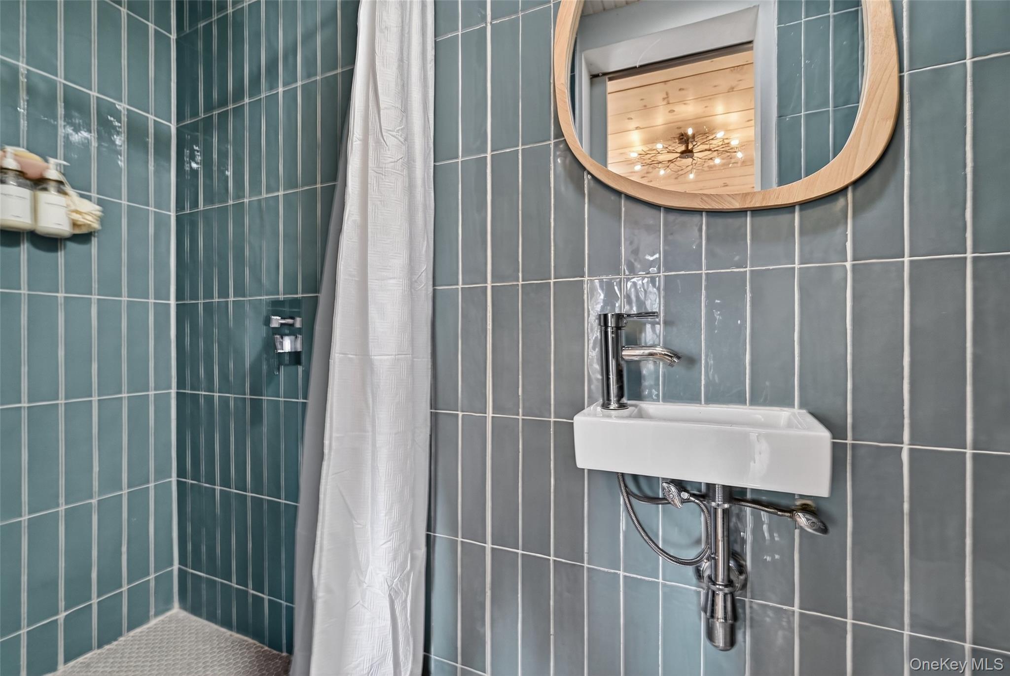 96 Lower Wisner Road Warwick, NY 10990 - Photo 27 of 34 Modern bathroom featuring floor-to-ceiling vertical subway tile, a wall-mounted rectangular basin, and a contemporary wood-framed mirror