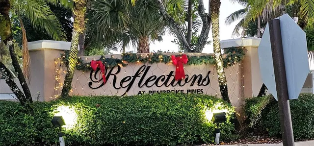 a view of a sign board with buildings in background