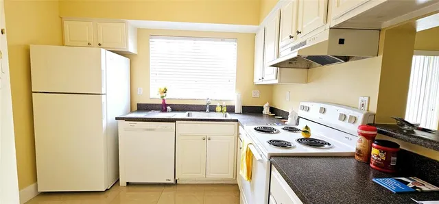 a kitchen with granite countertop a sink and a stove top oven