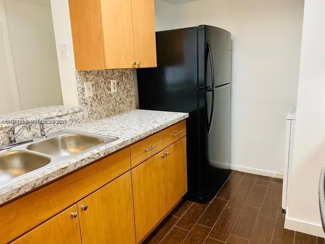 a kitchen with a refrigerator and a sink