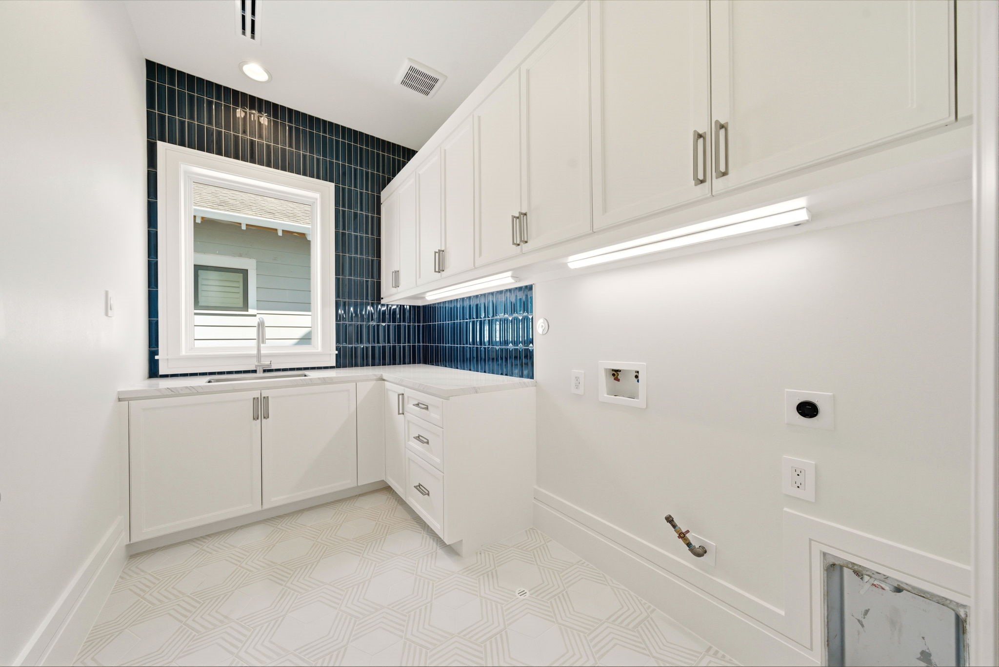 1023 Euclid Street Houston, TX 77009 - Photo 35 of 50 Designer utility room featuring custom cabinetry, striking blue tile backsplash, under-cabinet lighting, and generous prep space.