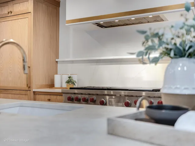 a kitchen with a stove a sink and a wooden floors