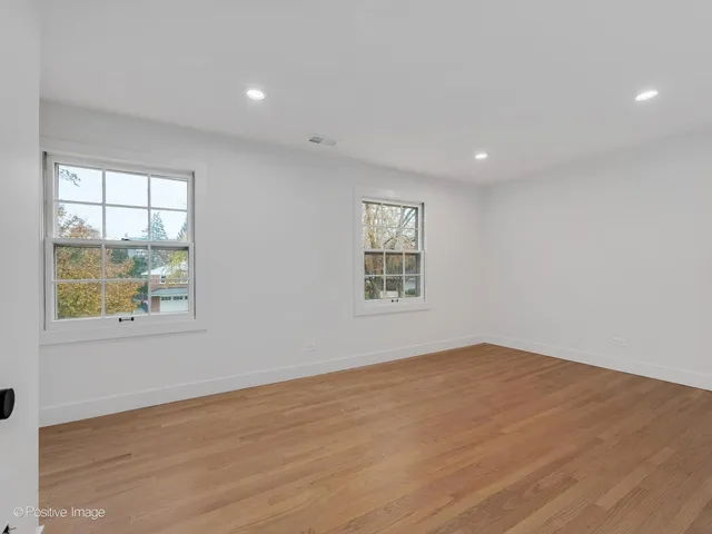 a large white kitchen with a large counter top and stainless steel appliances
