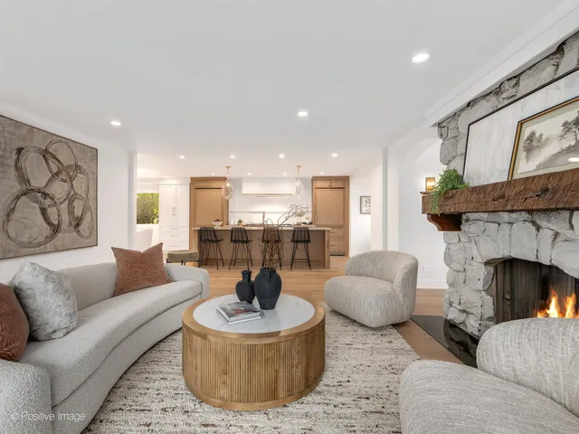 a living room with furniture chandelier and fireplace