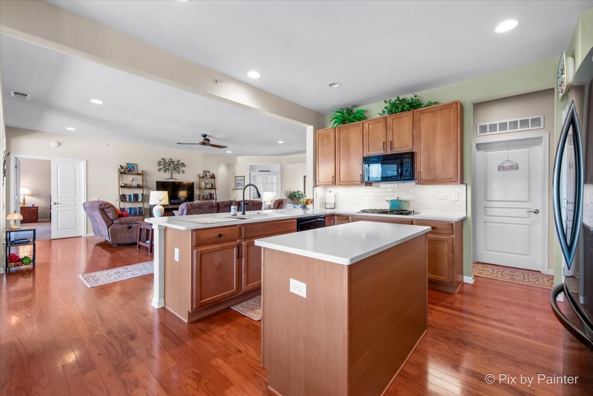 12290 Russet Lane Huntley, IL 60142 - Photo 12 of 38 a kitchen with a refrigerator a stove top oven a sink dishwasher and white cabinets with wooden floor