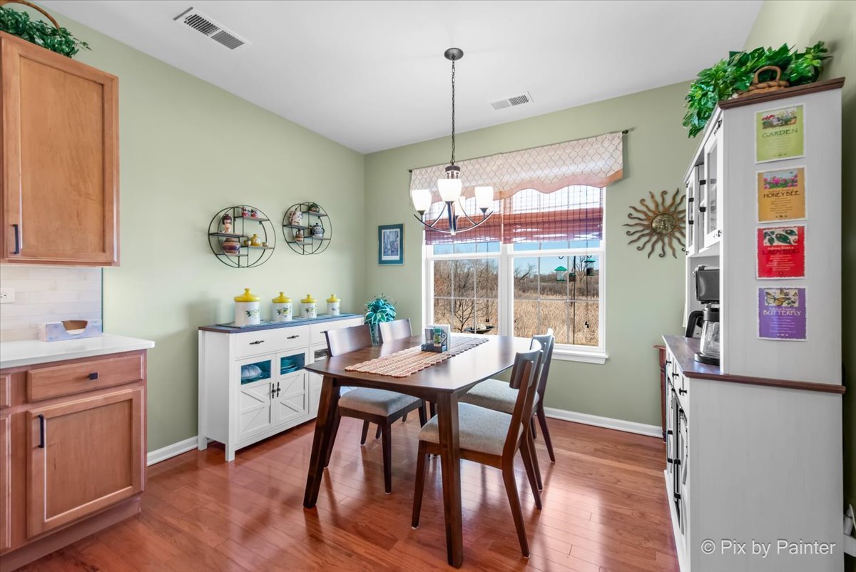 12290 Russet Lane Huntley, IL 60142 - Photo 16 of 38 a dining room with furniture a chandelier and wooden floor
