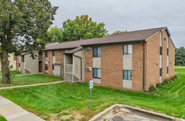 a backyard of a house with potted plants and large tree