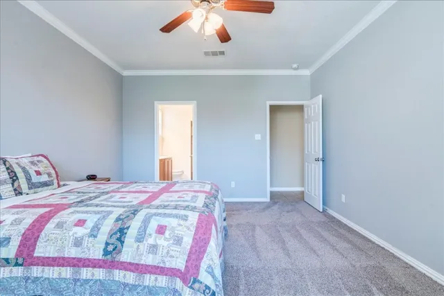 a bedroom with a large bed and a chandelier