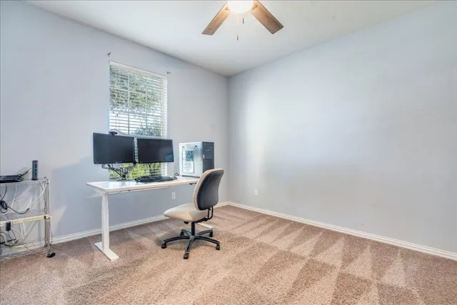 a view of a workspace with furniture and a window