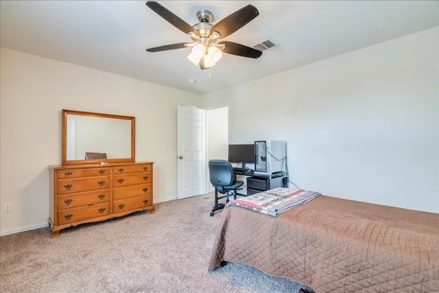 a bedroom with a bed and a ceiling fan