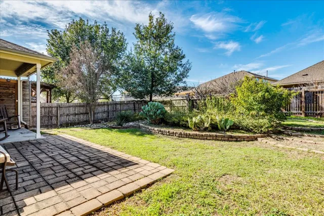 a view of a swimming pool with a yard and plants