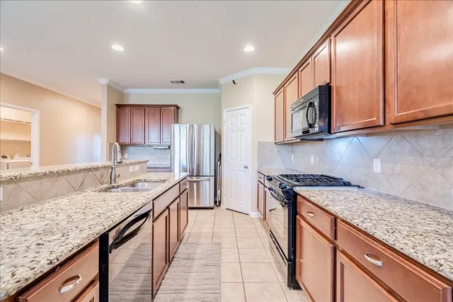 a kitchen with stainless steel appliances granite countertop a sink stove and refrigerator
