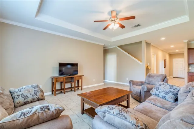 a living room with furniture and a ceiling fan