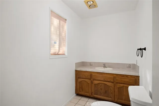 a bathroom with a granite countertop sink and a window